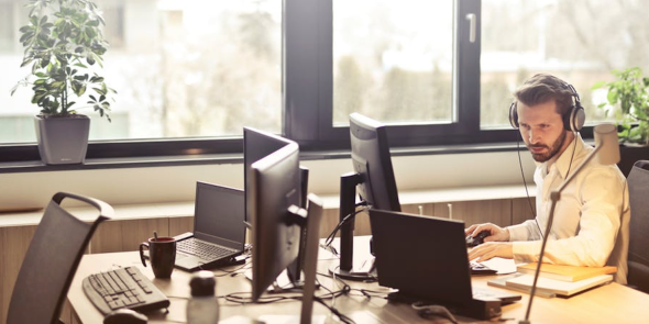 Man die achter zijn computer werkt met een geïntegreerd CRM systeem. De vraag wat is een CRM? Wordt beantwoord in deze blog.